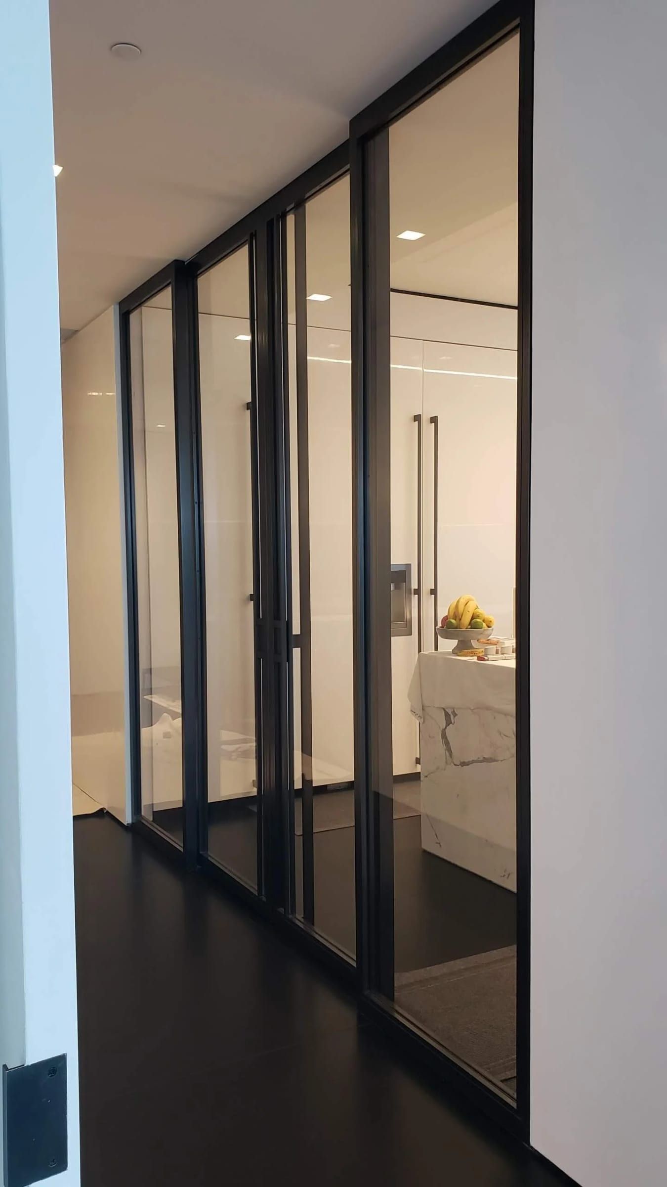 A run of blackened stainless glass doors