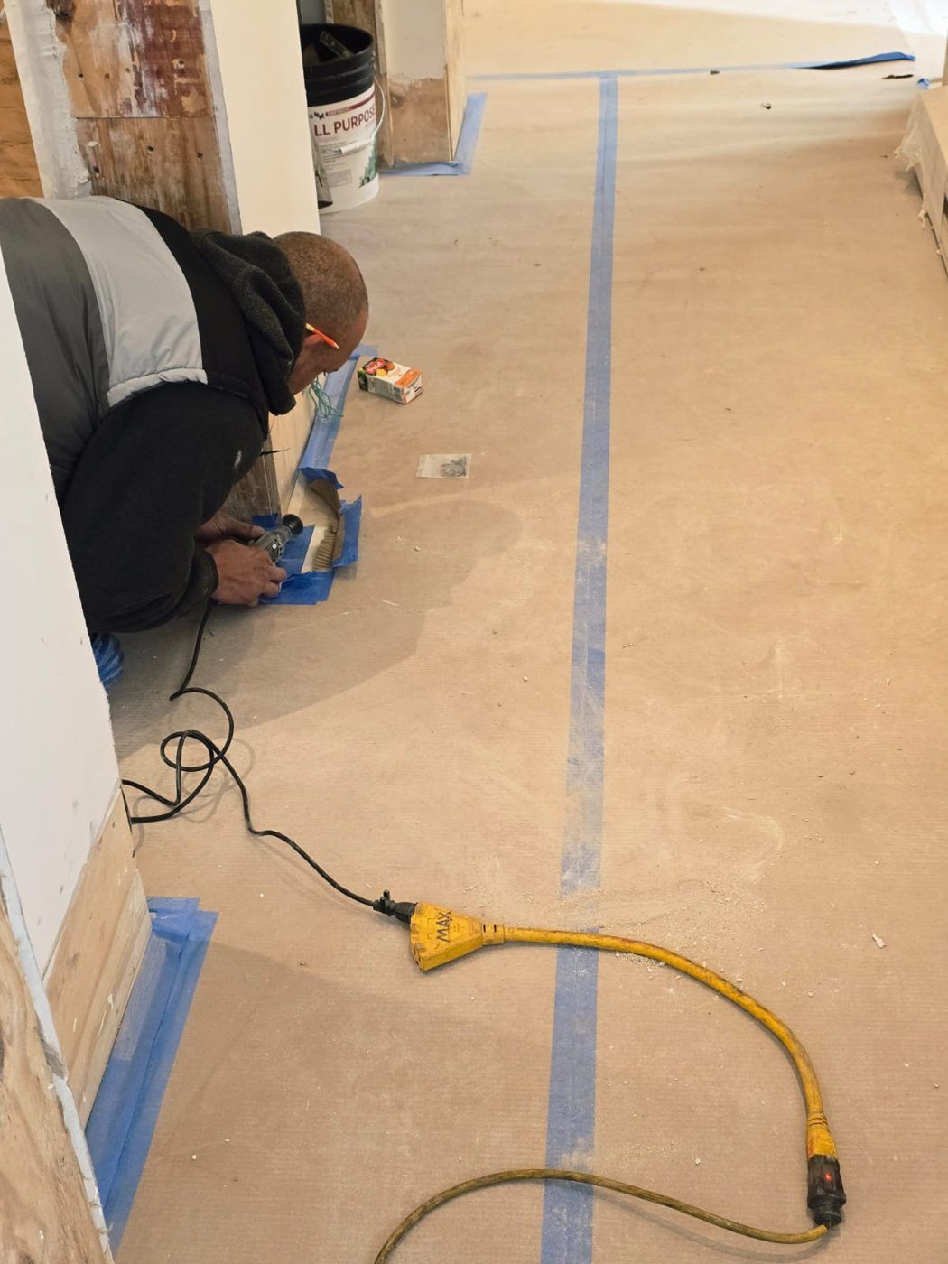 Installer working at floor level on a job site