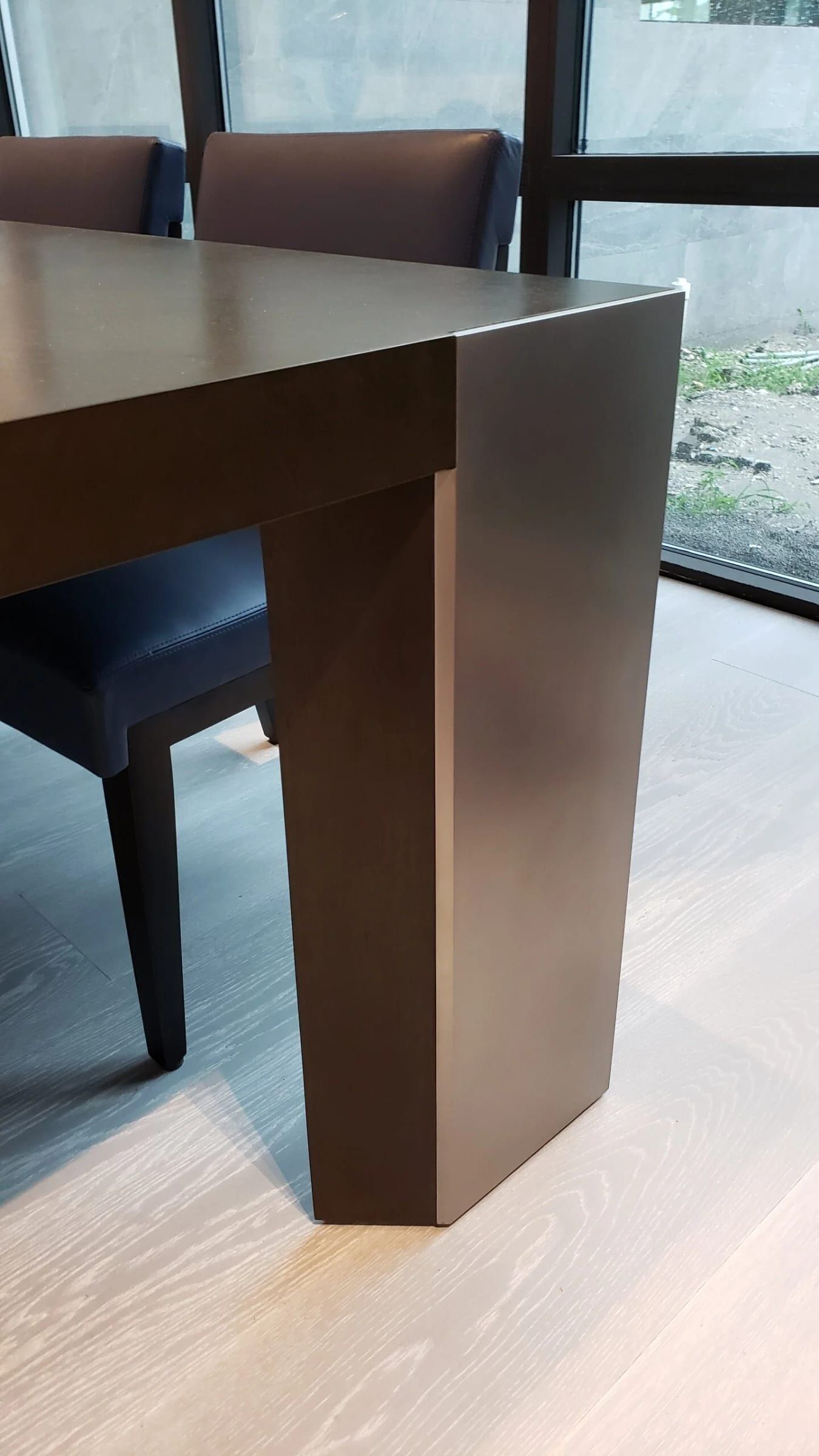 Corner of a dining table base in a dark metal finish
