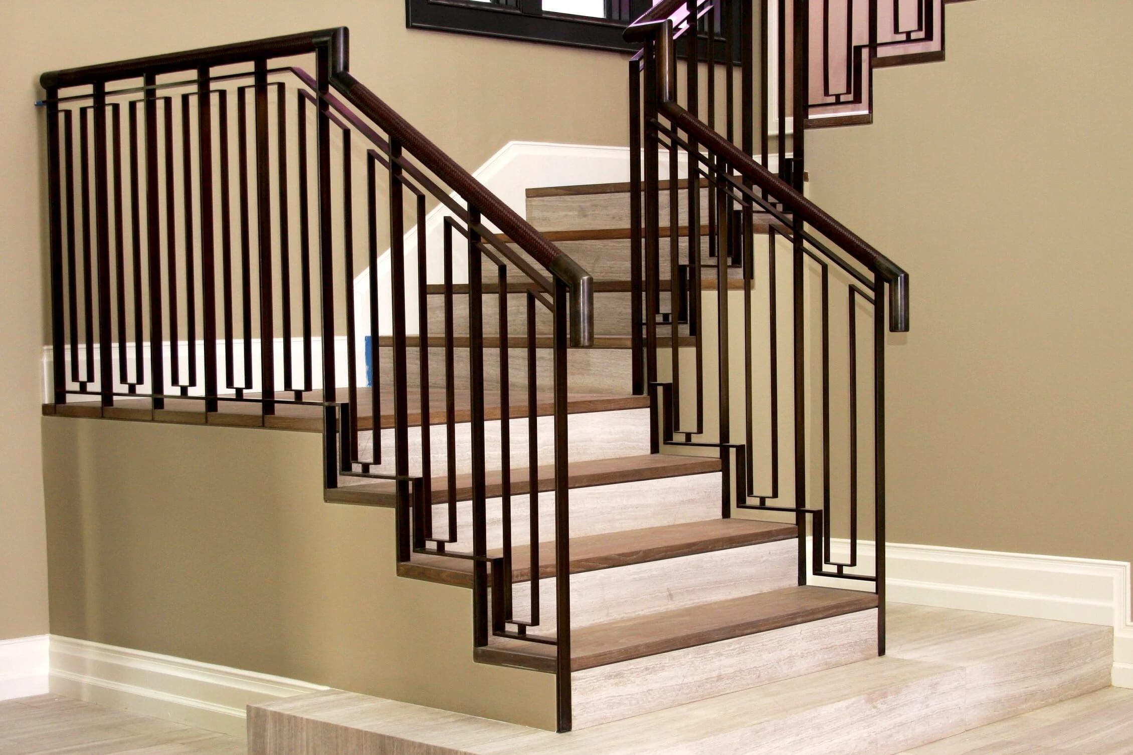 Staircase with a dark steel railing in a geometric pattern