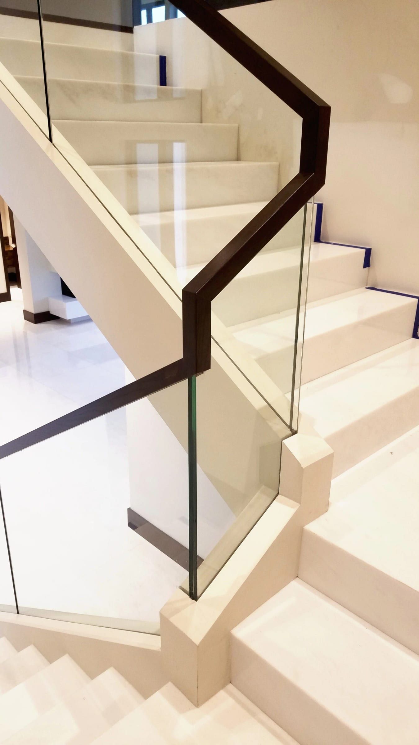 Glass stair balustrade with a dark handrail