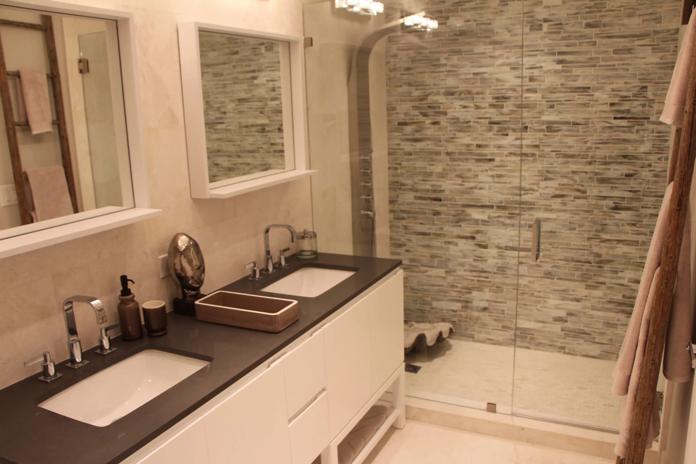 Double vanity and mosaic-tiled glass shower