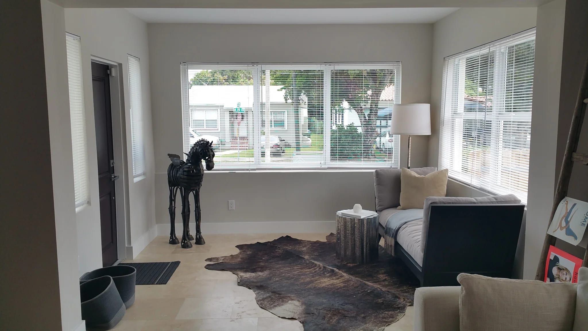 Living room with travertine floors and a sculpture by the window