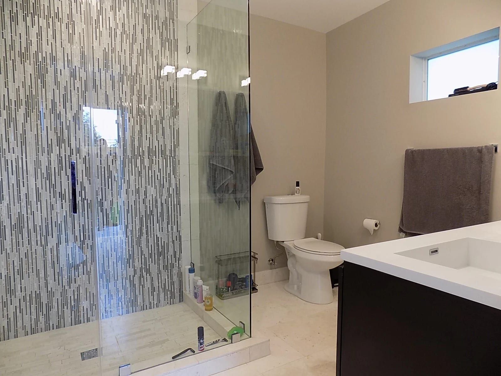 Bathroom with a glass mosaic shower wall