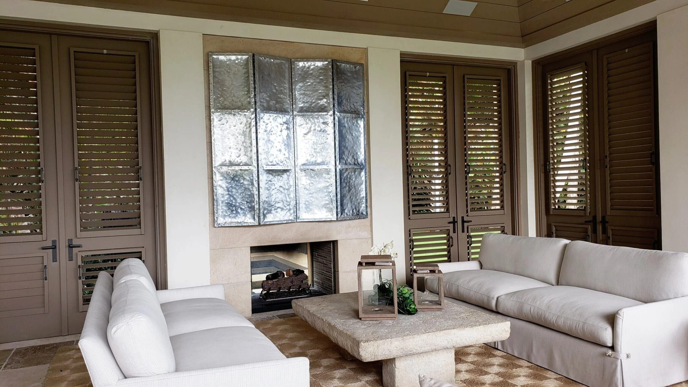 Covered patio with zinc panels above an outdoor fireplace